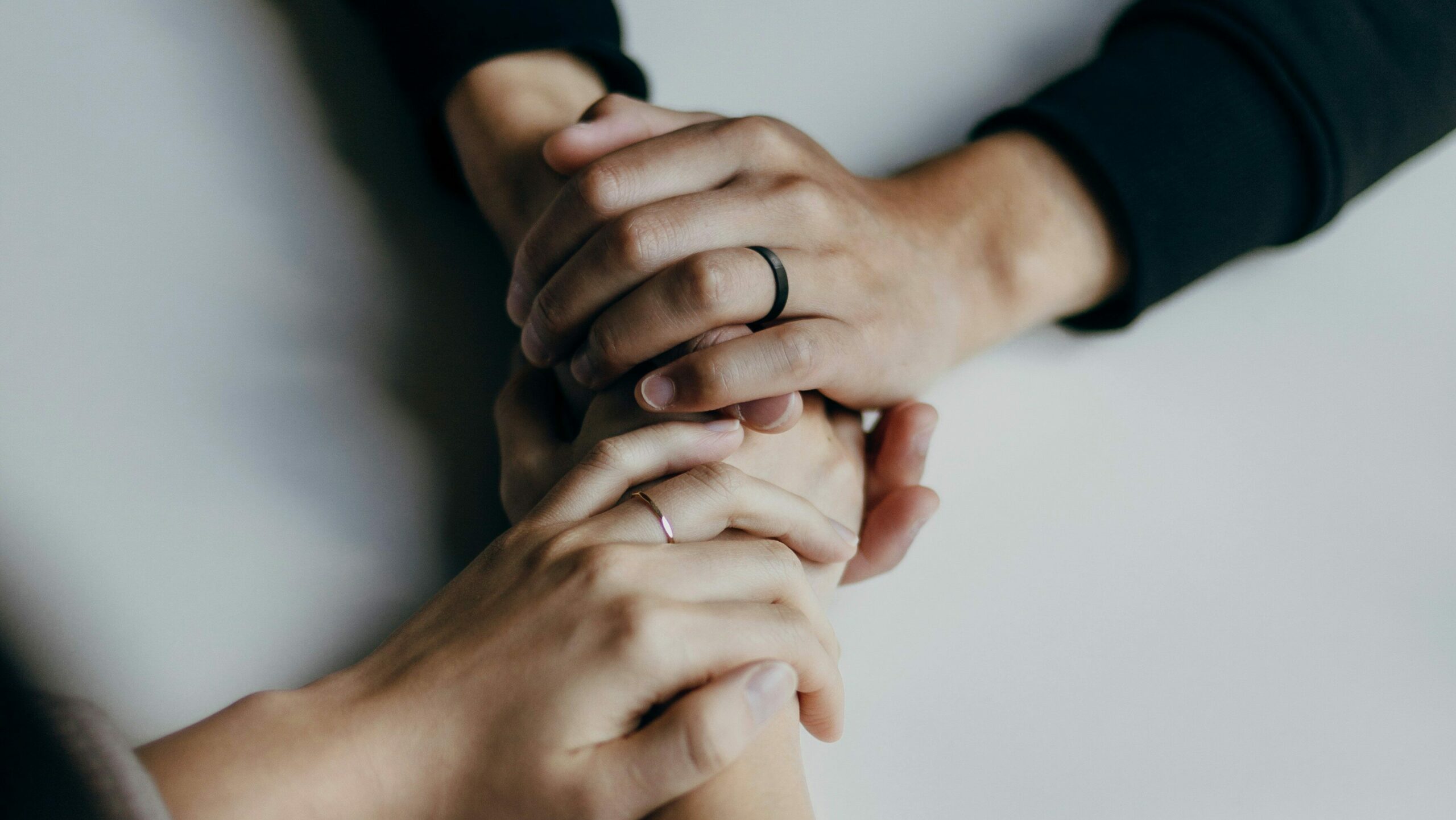 Close-up of two people holding hands, offering support and comfort. This image symbolizes the compassionate care and assistance provided by domestic violence services.