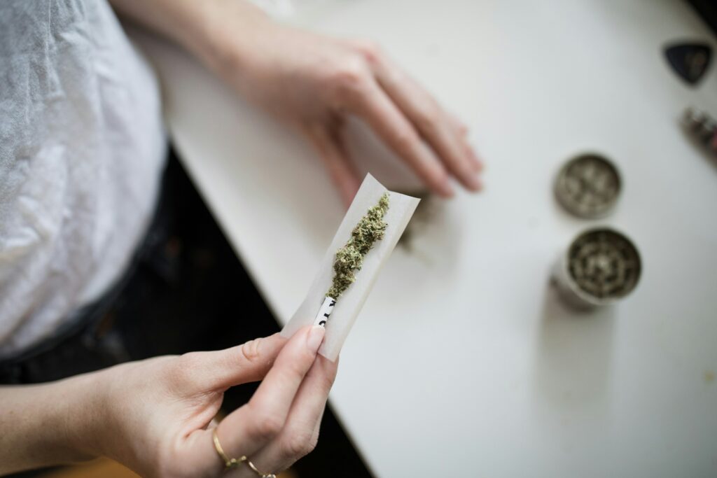 Close-up of a person rolling a marijuana joint, emphasizing the theme of 'marijuana use among youth.