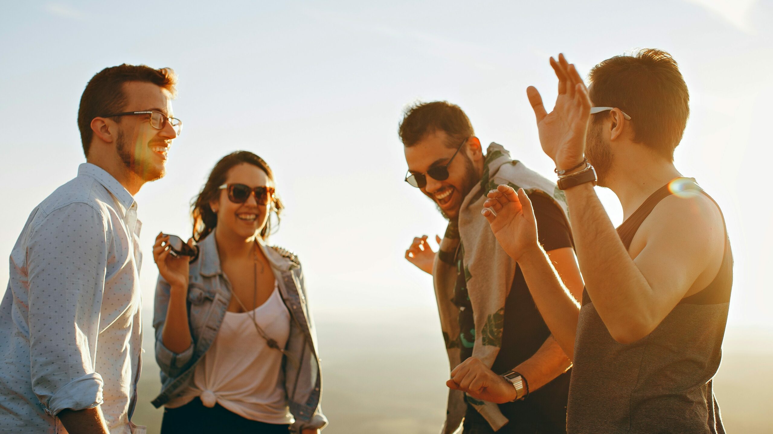 A group of friends enjoying a sunny day outdoors, laughing and having a good time, representing healthy and sober ways to enjoy summer as a contrast to summer substance use.