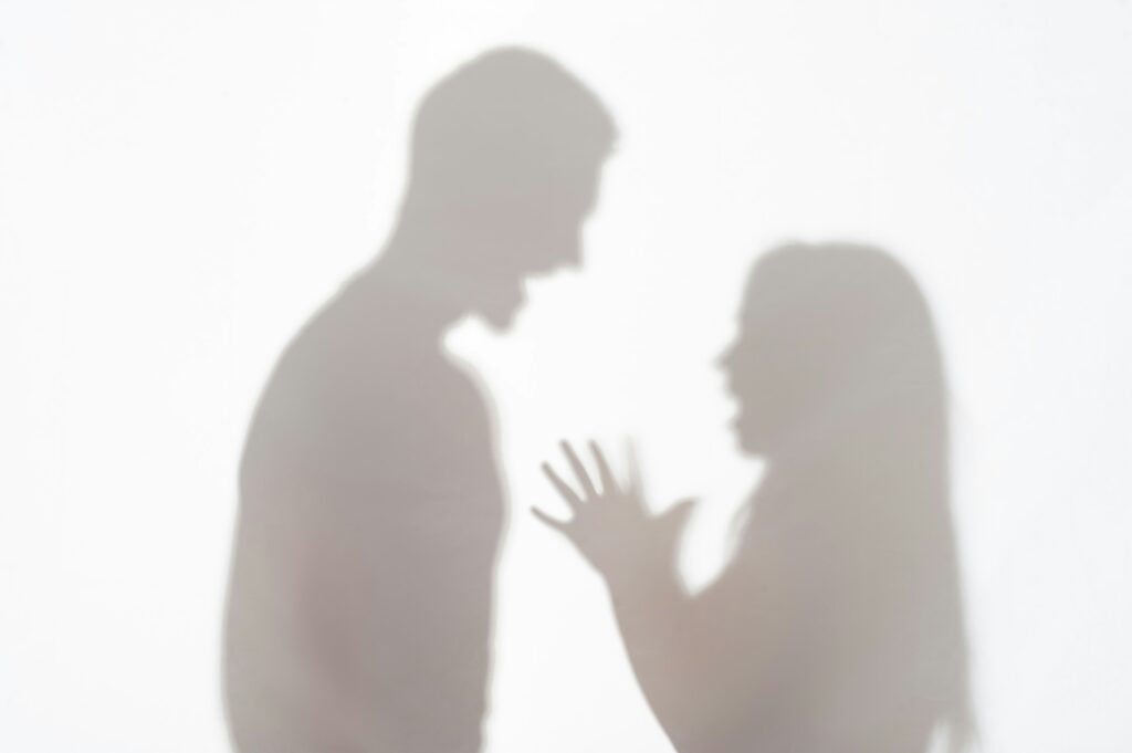 Silhouettes of a man and a woman fighting depicting a scene leading to domestic violence