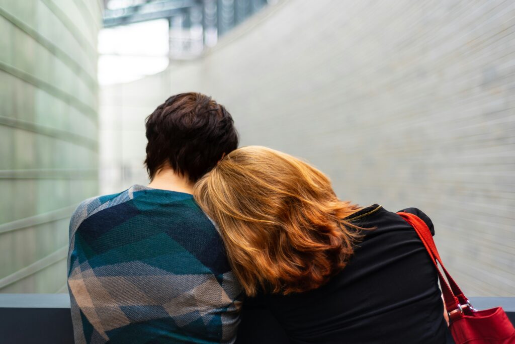 A man and a woman hugging while sitting on a staircase, showing a peaceful scene in a relationship
